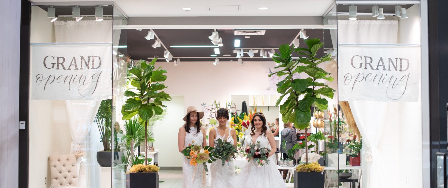 Calyx Floral Design boutique grand opening storefront photo with three brides holding bridal bouquets