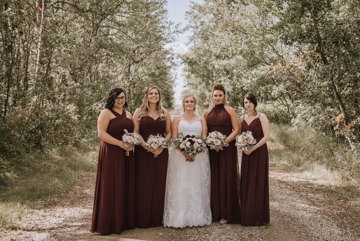 Bridesmaids with blush quicksand roses and bridal bouquet of burgundy dahlia and blush roses with dusty miller and silver dollar eucalyptus
