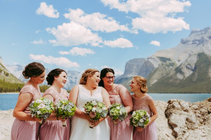 Bridesmaids in blush with bride in white holding succulent bouquets