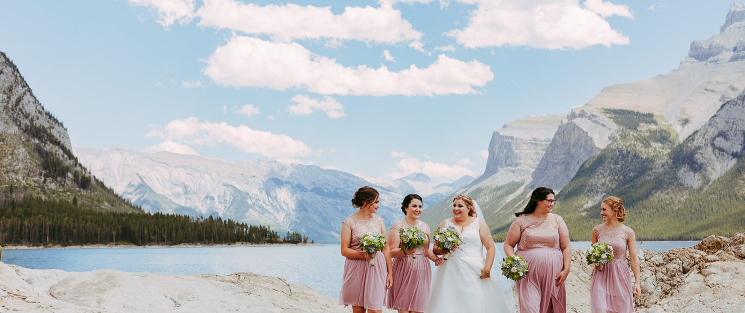 Bride with bridesmaids at a rocky mountain lake holding succulent and paper flower bridal bouqets