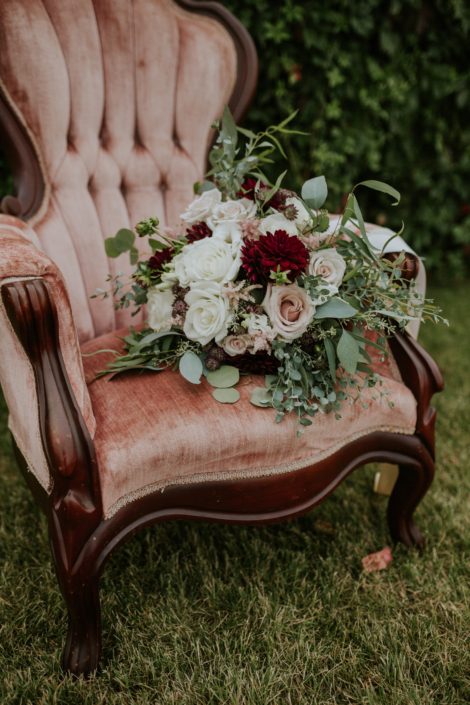 antique blush chair with bridal bouquet of burgundy, blush and ivory and eucalyptus greenery