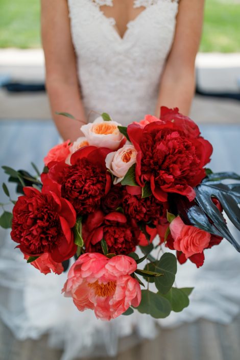 bridal bouquet designed with burgundy and coral peony, black monstera, eucalyptus and peach garden roses