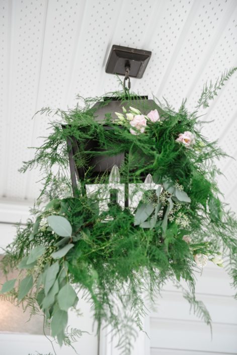 Black chandelier decorated with plumosa and silver dollar eucalyptus