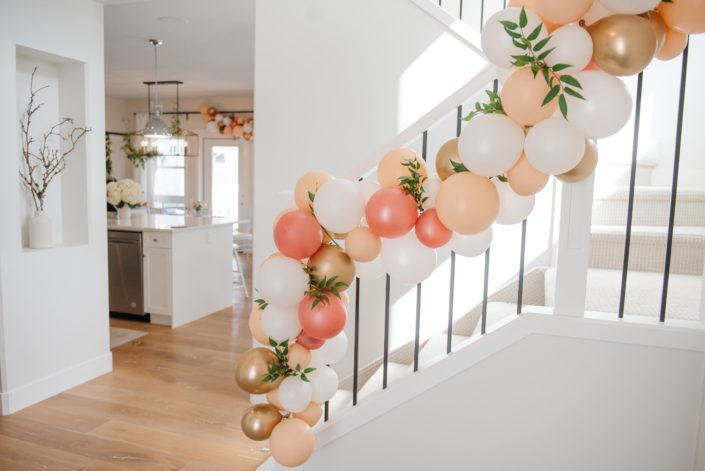 White and black stairwell with balloon garland accented by italian ruscus