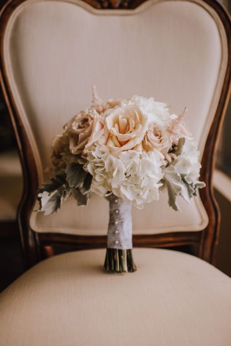 antique chair with bridal bouquet made with white hydrangea and blush quicksand roses and dusty miller