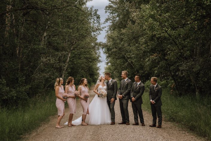 wedding party in blush and charcoal grey holding bouquets made with astilbe and white hydrangea