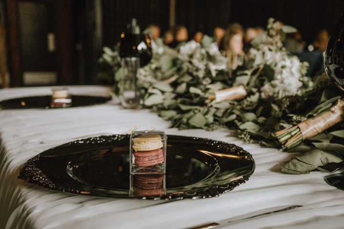 sweetheart table close up of macaron wedding favors and eucalyptus garland