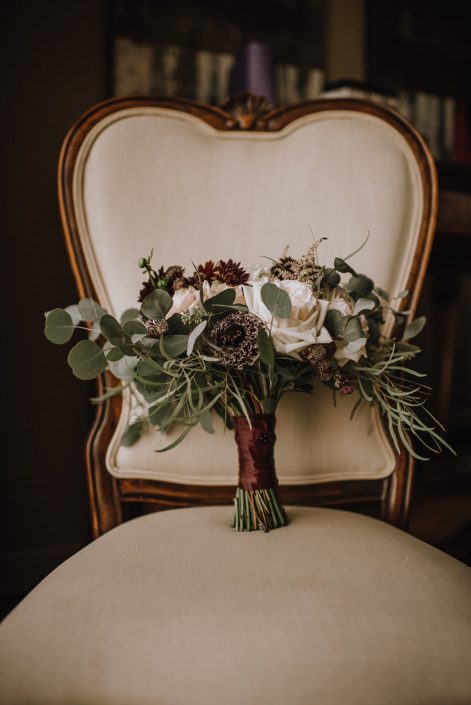 ntique ivory chair with burgundy plum and ivory bridal bouquet with eucalyptus