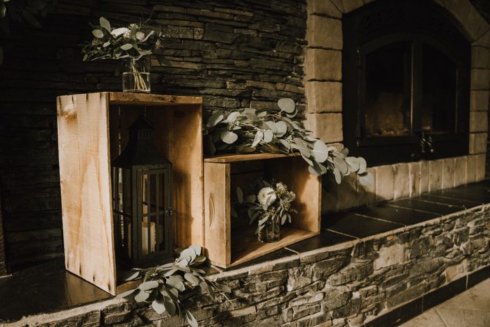 main room fireplace at Canyon Ski Resort decorated with wooden crates, lanterns and fresh eucalyptus greenery