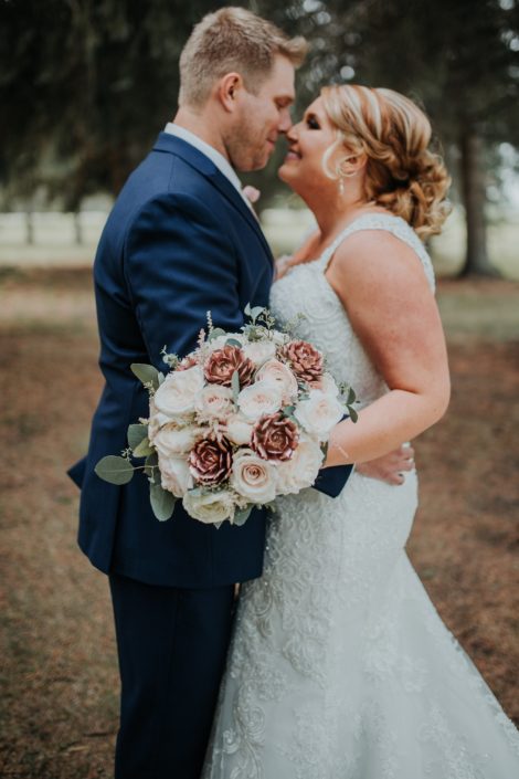 Bride and Groom holding bridal bouquet of rose gold succulents and garden roses and eucalyptus in a summer wedding