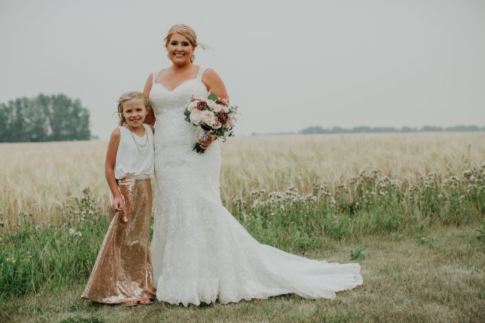 bride and flowergirl in rose gold sequin skirt and white top with bridal boqueut of rose gold succulents and ivory and blush roses and eucalyptus