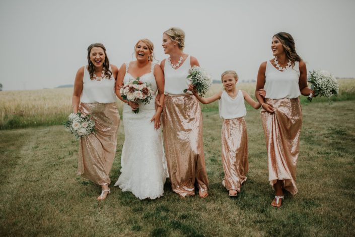 bride with bouquet of rose gold succulents and ivory garden roses and blush quicksand roses and bridesmaids in sequin rose gld skirts holding bouquets of babies breath and garden roses