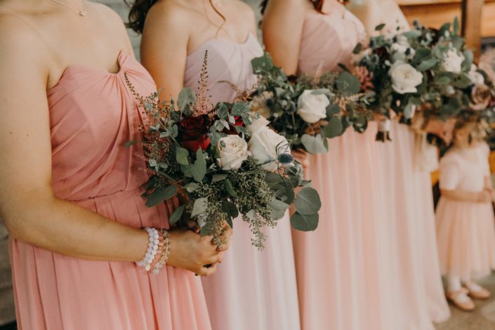 blush wedding party with bouquets made with quicksand roses and white o'hara garden roses and red roses and pink astilbe and eryngium and eucalyptus