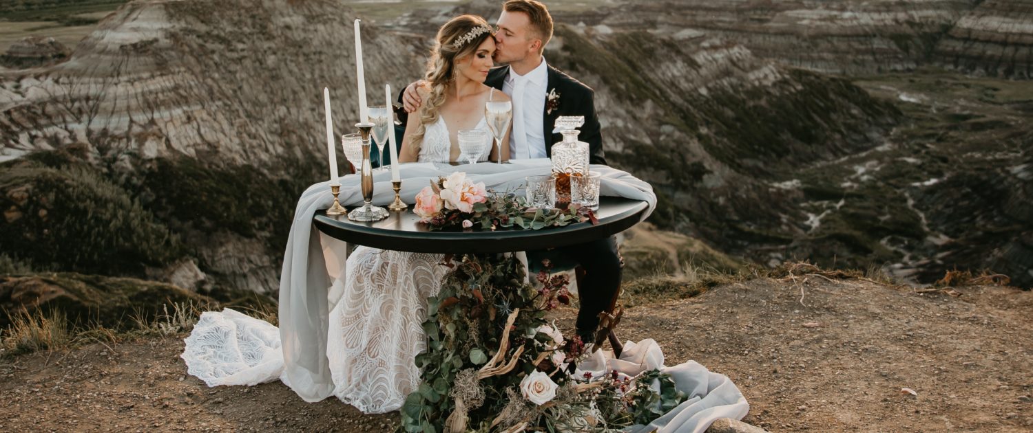sunset in the badlands photoshoot overlooking the hoodoos with bride and groom and floral accents