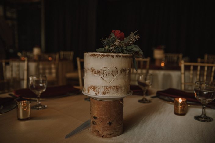 Naked cake wedding centerpiece with eryngium, seeded eucalyptus and hearts garden rose cake topper
