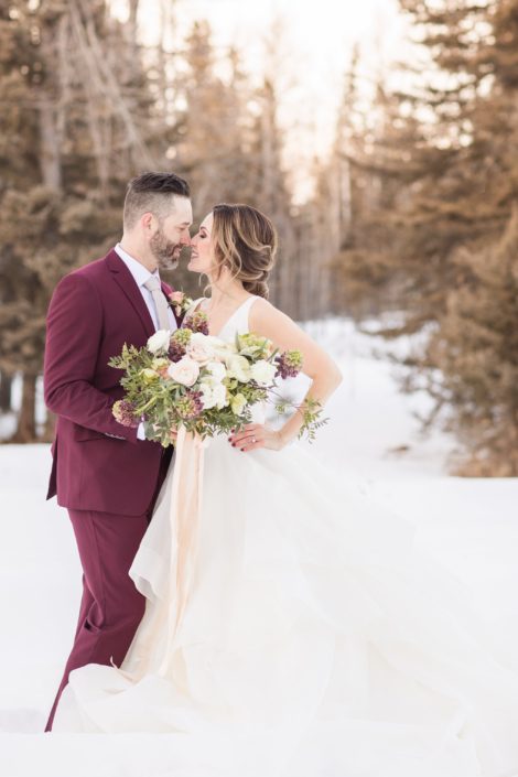Winter wedding bride and groom with burgundy frittilaria, blush roses and blush ranunculus