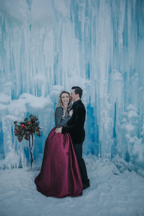 Ice castles engagement photos with burgundy taffeta skirt and bridal bouquet in burgundy