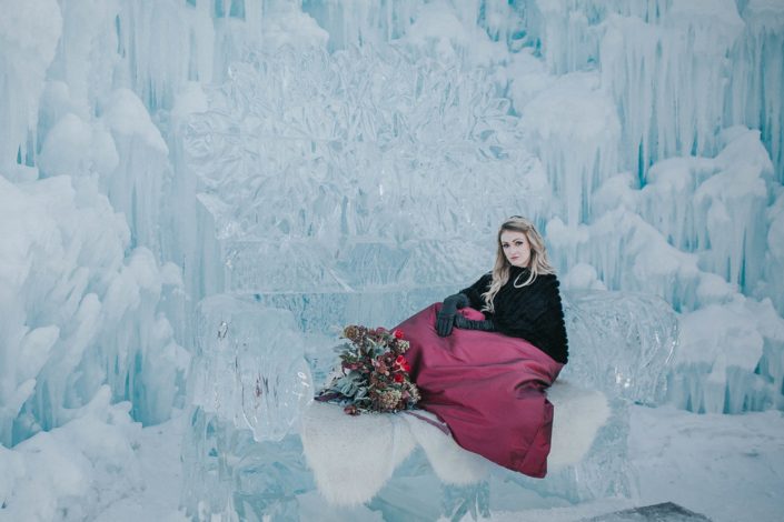 Engagement photos at the edmonton ice castles with a bridal bouquet of red tulips and burgundy flowers