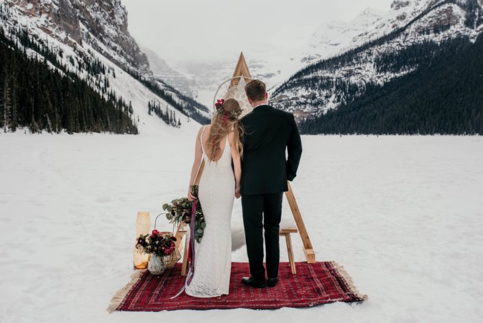 lake louise elopement with a triangle archway and burgundy floral accents