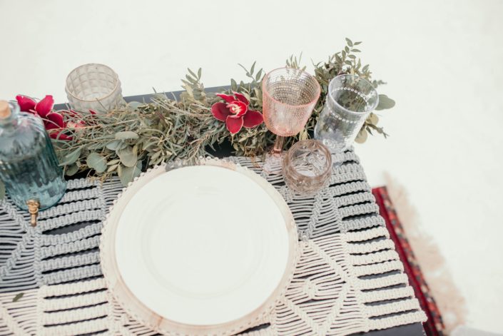 tp view of sweetheart table in a winter photoshoot with fresh eucalyptus greenery garland and burgundy orchids