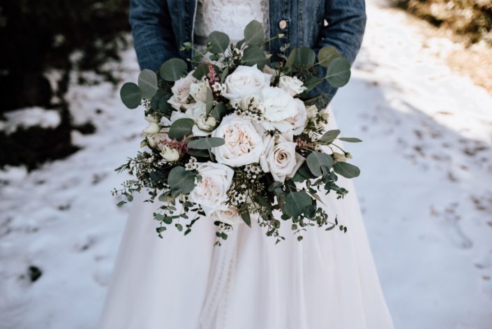 bride holding bouquet of playa blanca and quicksand roses, waxflower and eucalyptus