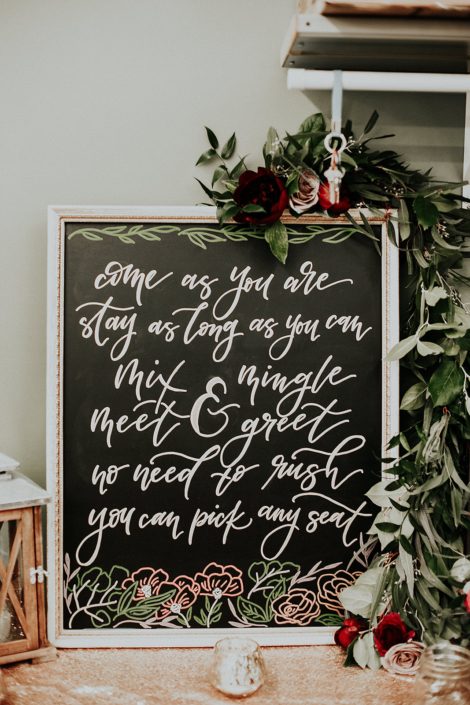 Rustic Boho Chic Wedding - come as you are stay as long as you can sign draped with garland made of greenery, and red and blush roses