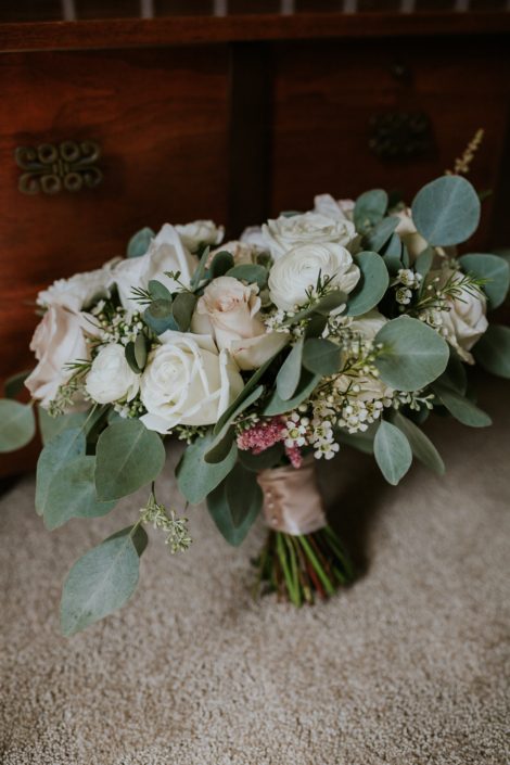 Brooke's ivory and blush pink bridal bouquet made with White O'hara garden roses, quicksand roses, white ranunculus, astilbe, white playa blanca roses, waxflower and mixed eucalyptus greenery.