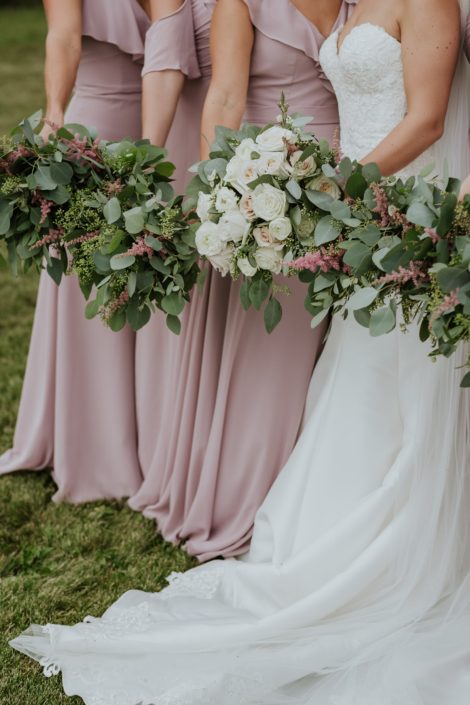 Blush bridesmaid dresses and white bridal gown with eucalyptus greenery and pink astilbe bridesmaid bouquets and a blush and ivory bridal bouquet designed with white o'hara garden roses, quicksand roses, playa blanca roses, ranunculus, wax flower, astilbe and eucalyptus greenery.