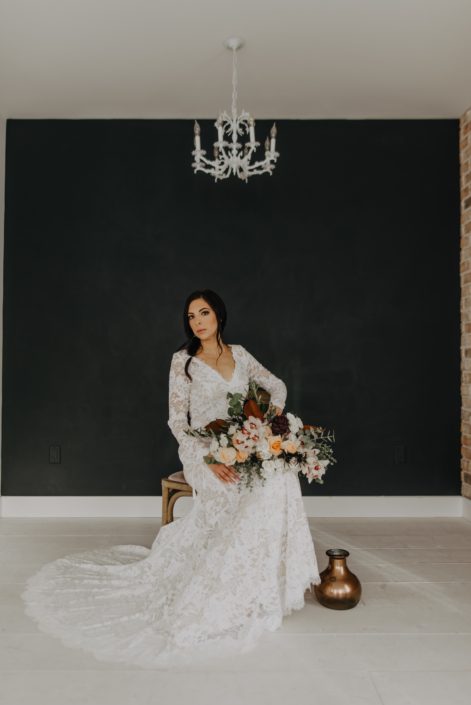 Neutrals Styled Shoot with Down the Aisle - Bride wearing lace gown holding neutral bouquet of orchids, roses, magnolia leaves and eucalyptus greenery.