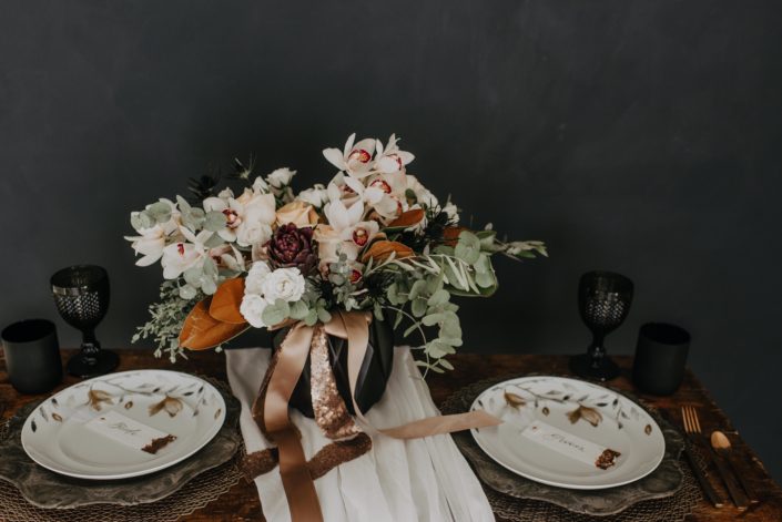Neutrals Styled Shoot with Down the Aisle - Neutral coloured bridal bouquet with peach roses, orchids, magnolia leaves and eucalyptus greenery tied with trailing ribbon atop a decorated sweetheart table.