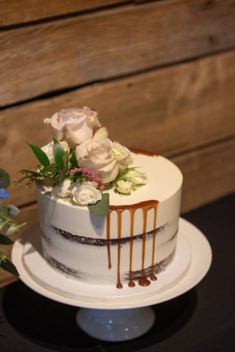 Naked cake with fresh florals on top including quicksand roses, astilbe and eucalyptus greenery.