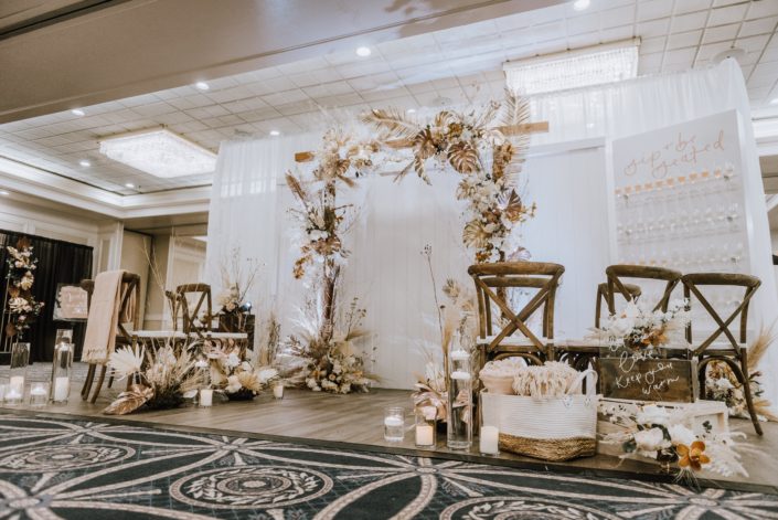 Down the Aisle Wedding Show 2020 Calyx Floral Design booth decorated with gold painted monstera leaves, painted sago palm, pampas grass, playa blanca roses, quicksand roses and other dried foraged leaves and branches.