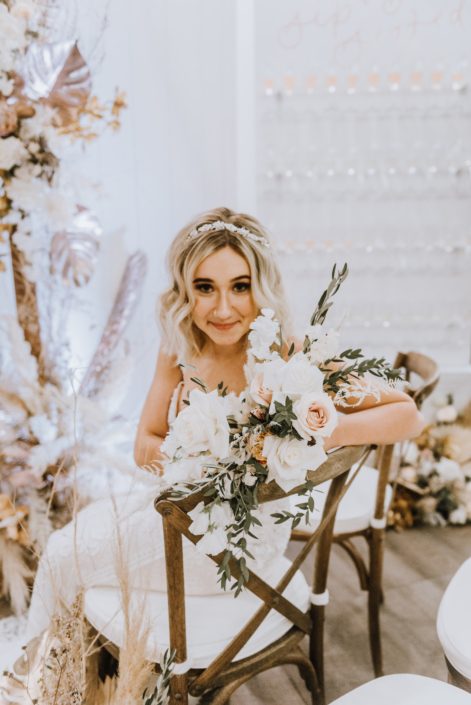 The model at the Down the Aisle Wedding Show 2020 holding a bouquet made of eucalyptus, pale pink roses, Playa Blanca roses, Japanese white sweet peas and dried leaves.