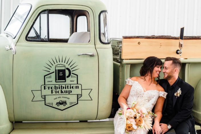 Bride and groom sitting on the Prohibition Pickup.
