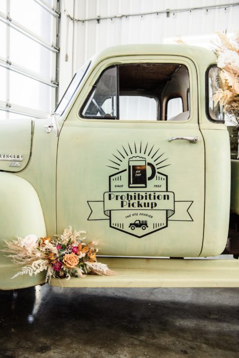 The Prohibition Pickup decorated with dried floral arrangements made of pampas grass, roses, ranunculus and various other botanicals.