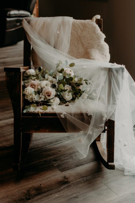 Erika's blush, ivory and white bridal bouquet on a wooden rocking chair with her veil.