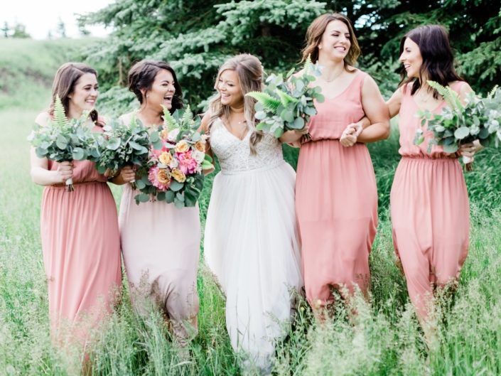 Bride, Taylor and her bridesmaids - Taylor is carrying a modern coral charm peony bouquet with accents of golden mustard roses, quicksand roses, cappuccino roses, astilbe, boston fern, monstera leaf and eucalyptus greenery. Bridesmaids are carrying bouquets made a mixed variety of eucalyptus and boston fern greenery.