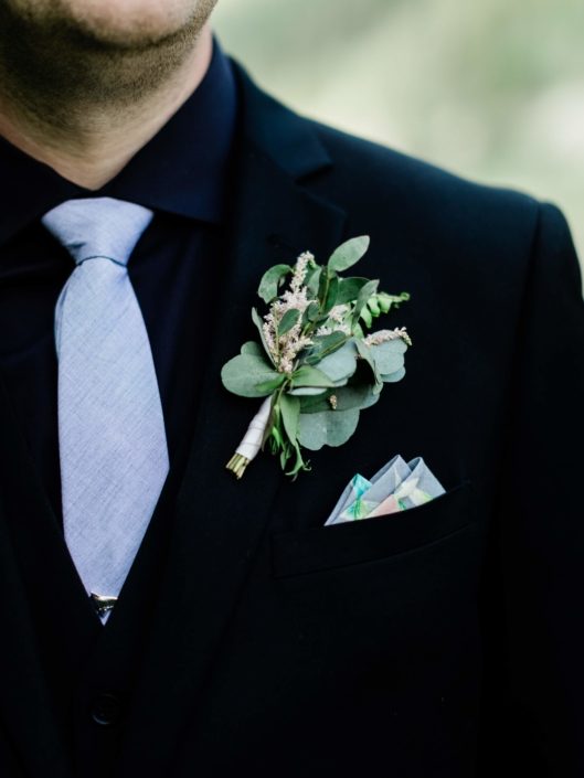 Groom's boutonniere made of pale pink astilbe, and eucalyptus greenery.