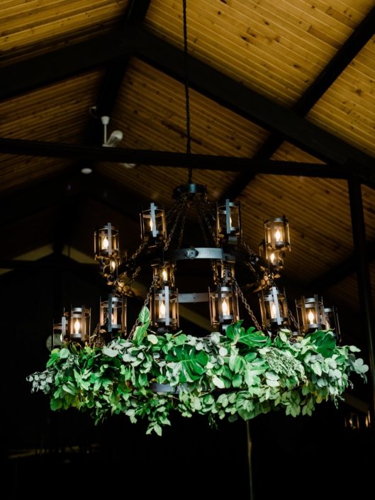Chandelier at Canyon Ski Resort adorned with lush fresh greenery including salal, monstera leaves and eucalyptus greenery.