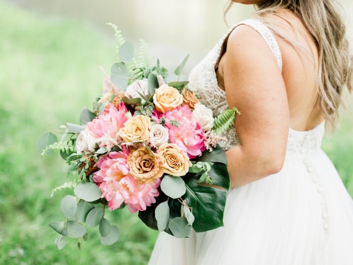 Modern Coral Charm Peony bouquet with monstera leaf, golden mustard roses, cappuccino roses, quicksand roses, boston fern and eucalyptus.