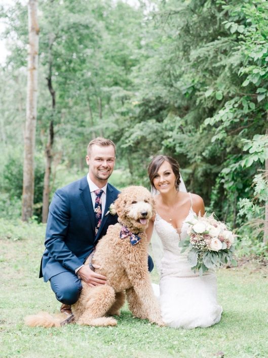 Bride and groom with dog wearing a bow tie. Bride is holding a elegant rustic dusty rose bridal bouquet featuring white o'hara garden roses, rose gold painted scabiosa pods, amnesia and quicksand roses, ranunculus, astilbe, babies breath, dusty miller and eucalyptus.