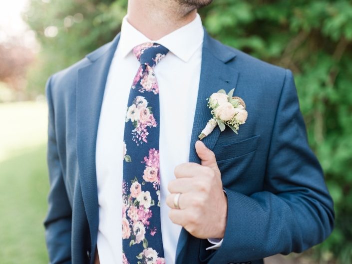 Bride wearing navy and a rose gold boutonniere.