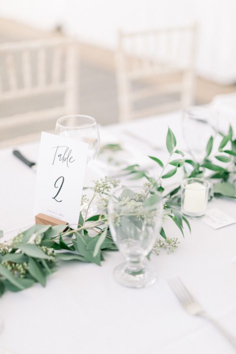 Simple elegant table cards and fresh greenery garland centrepieces of eucalyptus and Italian ruscus.