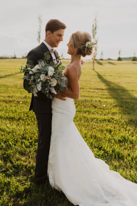 Leah and Chance's vintage white and grey green wedding; bridal bouquet featuring white playa blanca roses, lisianthus and astilbe with Blue Star succulents accented by grey toned greenery such as dusty miller and mixed varieties of eucalyptus.