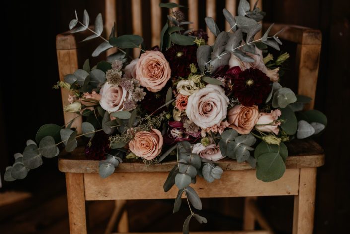 Crystal and Chance's Sweet Haven Barn Wedding - Crystal's bridal bouquet designed with pale pink astrantia, burgundy cymbidium, burgundy dahlias, peach lisianthus, cappuccino roses, quicksand roses and a mixed variety of eucalyptus greenery.