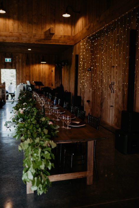 Head table covered in fresh greenery garland for Crystal and Chance's Sweet Haven Barn Wedding