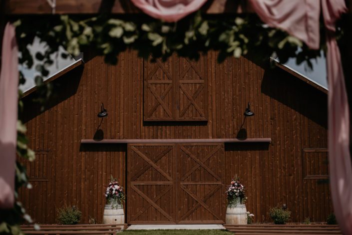 Sweet haven barn with barrels topped with floral arrangements.