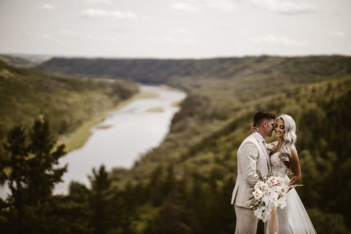 Bride and groom overlooking a rivervalley with glam boho bridal bouquet featuring roses, pampas grass and orchids.