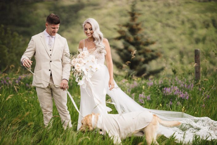 Bride and groom, Sandra and Brandon, with dog in a suit and boho glam bridal bouquet featuring phalenopsis orchids, quicksand roses, pampas grass, olive branches and eucalyptus greenery.