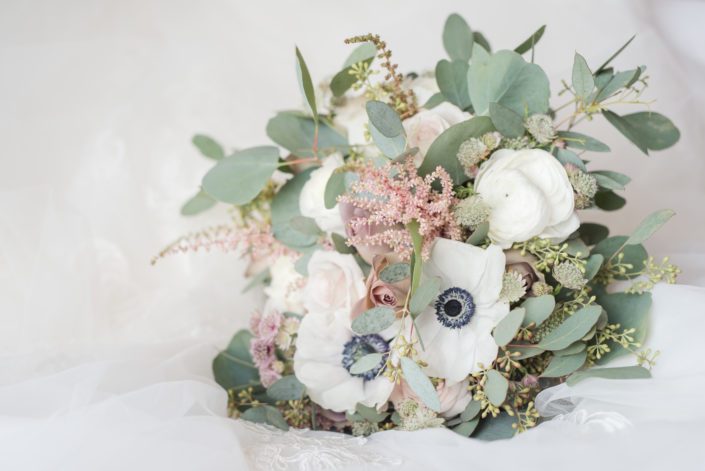 Amber's Elegant Mauve and Ivory Bridal Bouquet featuring panda anemones, light pink astilbe, white astrantia, white ranunculus, amnesia roses, quicksand roses and a variety of eucalyptus greenery.